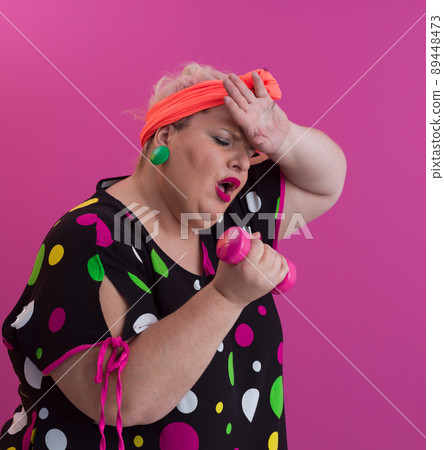 Fat woman dieting, fitness and healthy food at home.Big woman and sport. Health, fitness and sports concept. Plus size young caucasian woman doing exercise with dumbbells in cozy bedroom interior 89448473