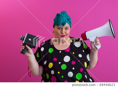 Funny plus size woman woman posing isolated on pink background studio portrait. People emotions lifestyle concept. Mock up copy space. Screaming in megaphone.  89448621