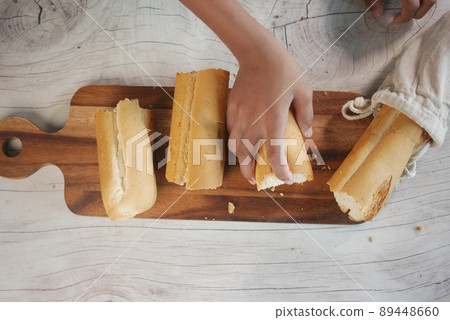 cutting baked brow bread on table. 89448660