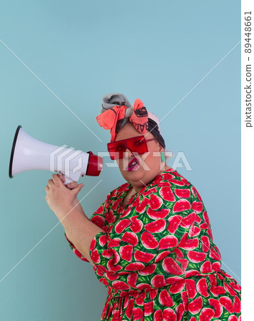 Funny plus size woman posing isolated on cyan background studio portrait. Screaming in a megaphone. People emotions lifestyle concept. Mock up copy space.  89448661