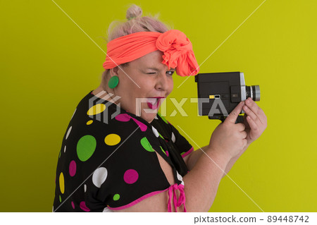 plus size smiling woman with funny emotional face expression with vintage camera in dress isolated on green background, traveler on vacation, summer fashion style, excited tourist. plus size smiling woman with funny emotional face expression with vintage camera in dress isolated on green background, traveler on vacation, summer fashion style, excited tourist. 89448742