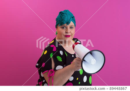Funny plus size woman woman posing isolated on pink background studio portrait. People emotions lifestyle concept. Mock up copy space. Screaming in megaphone.  89448867