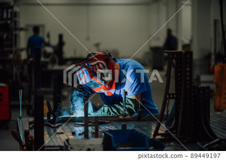 Professional Heavy Industry Welder Working Inside factory, Wears Helmet and Starts Welding. Selective Focus 89449197