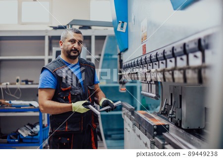A smart factory worker or engineer makes machines in a production workshop. The concept of industry and engineering. Selective focus A smart factory worker or engineer makes machines in a production workshop. The concept of industry and engineering. Selective focus 89449238