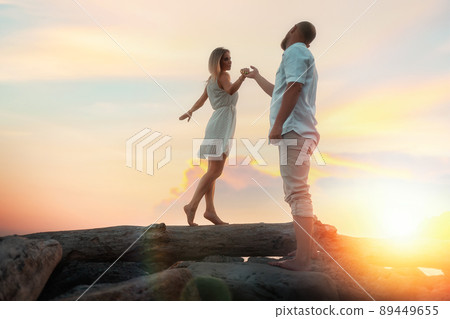 Valentines day. Pretty couple of young caucasians man and woman at romantic date. In the background sunset. Summertime Valentines day. Pretty couple of young caucasians man and woman at romantic date. In the background sunset. Summertime 89449655