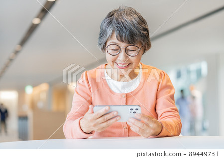 在智能手機上觀看視頻 戴眼鏡的高級女性 拍攝合作“LINK FOREST” 89449731