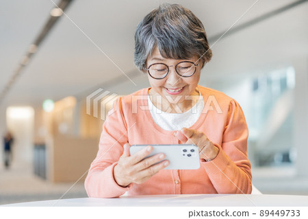 Senior woman operating a smartphone shooting cooperation "LINK FOREST" 89449733