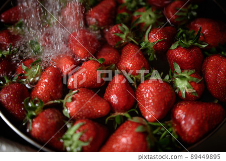 Juicy ripe red strawberries are washed in a steel bowl full of water. Juicy ripe red strawberries are washed in a steel bowl full of water. 89449895