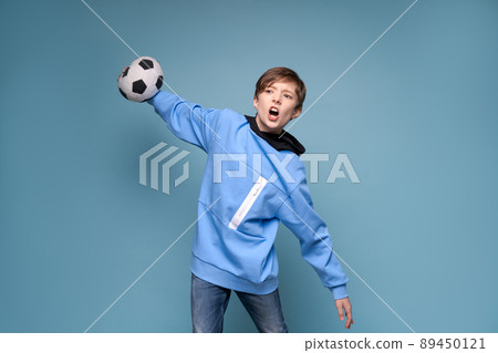 Joyful young man in blue sweatshirt posing isolated on blue wall background. Joyful young man in blue sweatshirt posing isolated on blue wall background. 89450121