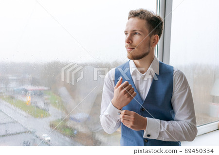 Portrait an arrogant sharp dressed man in blue suit correcting button 89450334