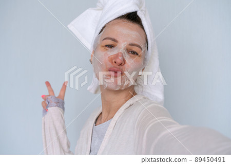 Woman having fun with face mask. Face portrait charming, stylish beautiful 89450491