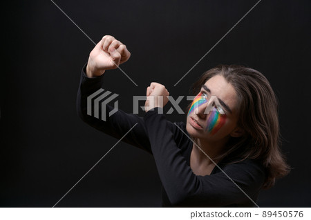 Flag LGBT lizbian woman with rainbow tears on her cheek defends herself Flag LGBT lizbian woman with rainbow tears on her cheek defends herself 89450576