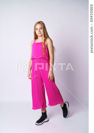 Beautiful teen girl posing in pink on a white background Beautiful teen girl posing in pink on a white background 89450869