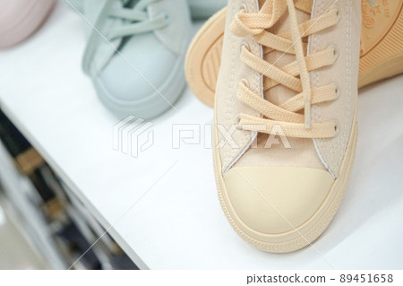 Pastel sneakers on display shelf for sales at sports shop in department store. Pastel sneakers on display shelf for sales at sports shop in department store. 89451658