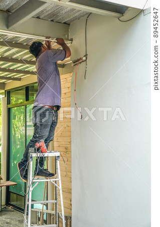 electrician repair swicht and electric wire on the wall. electrician repair swicht and electric wire on the wall. 89452647