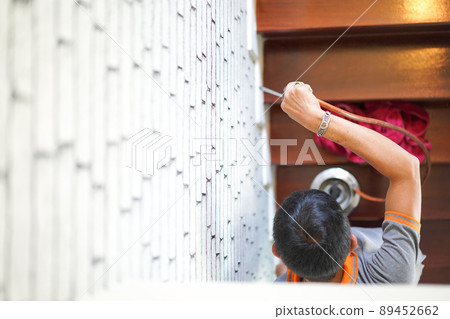 Pest / termites control services on wood stair in the new house that have termites signs inside it. focus on staff's hand. 89452662