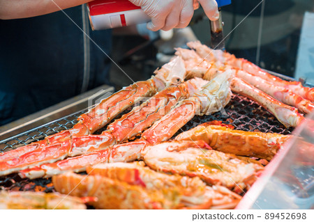 Grilled shrimps and crab on the grill are fire and cooked in fish market, Japan Grilled shrimps and crab on the grill are fire and cooked in fish market, Japan 89452698