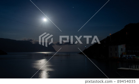 A nighttime seascape. The cove is illuminated by the moon. Front view. 89454035
