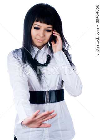 Young talking woman by mobile over white 89454058