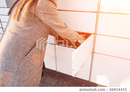 Postal terminal. Post delivery automat service and hands with parcel courier box. Mail delivery and post service concept. Postal terminal. Post delivery automat service and hands with parcel courier box. Mail delivery and post service concept. 89454435