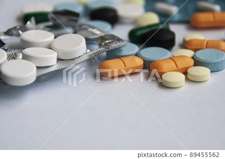 Assorted pharmaceutical medicine pills, tablets and capsules with blurred background over white background. Concept of healthcare and medicine. Assorted pharmaceutical medicine pills, tablets and capsules with blurred background over white background. Concept of healthcare and medicine. 89455562