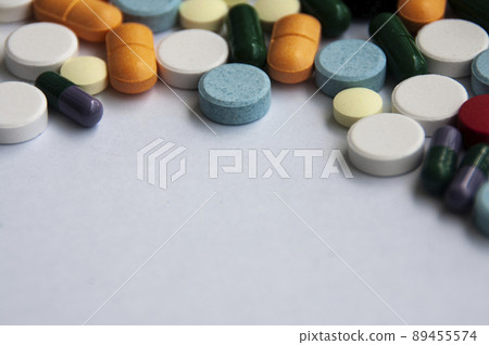 Assorted pharmaceutical medicine pills, tablets and capsules with blurred background over white background. Concept of healthcare and medicine. Assorted pharmaceutical medicine pills, tablets and capsules with blurred background over white background. Concept of healthcare and medicine. 89455574