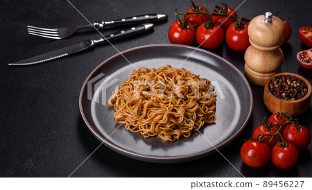 Buckwheat flour noodles with sauce, sesame, herbs and spices on a dark concrete background Buckwheat flour noodles with sauce, sesame, herbs and spices on a dark concrete background 89456227