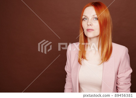 Portrait of special young woman with bright red color of hair standing against isolated background 89456381