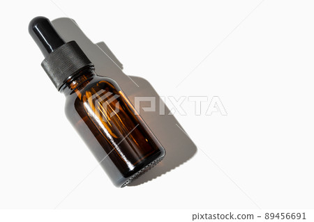 Essential oil amber bottle with pipette isolated on white background. Copy space 89456691