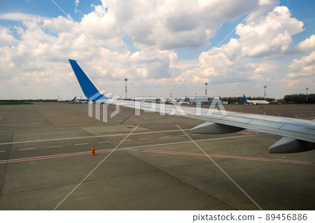 View of jet airplane wing taxiing runway after landing at airport. Travel and air transportation concept. View of jet airplane wing taxiing runway after landing at airport. Travel and air transportation concept. 89456886