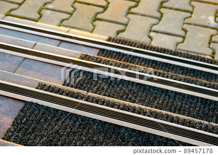 Closeup of ceramic tiles covering porch stairs with rubber anti slippery stripes on it. Closeup of ceramic tiles covering porch stairs with rubber anti slippery stripes on it. 89457178