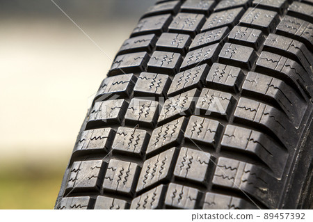 Close up detail of new black rubber car tire protector, selective focus, on copy space background. Close up detail of new black rubber car tire protector, selective focus, on copy space background. 89457392