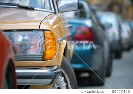 City traffic with cars parked in line on street side. 89457406