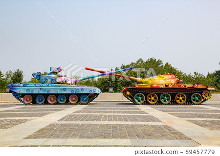 Tanks are painted in bright colors. Military Vehicles are painted with flower patterns. Tanks with crossed barrels. Anti-war concept. War and Peace. Russian invasion of Ukraine Tanks are painted in bright colors. Military Vehicles are painted with flower patterns. Tanks with crossed barrels. Anti-war concept. War and Peace. Russian invasion of Ukraine 89457779