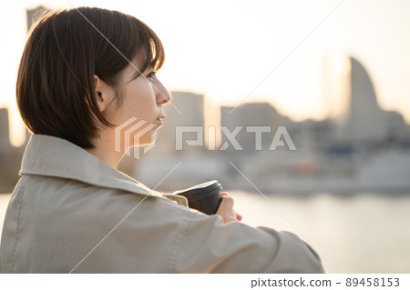 A pensive woman drinking coffee outdoors 89458153