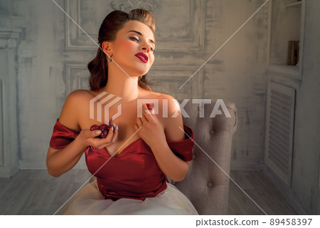 Pretty coquettish pin-up girl eats cherry in retro interior, Temptation Pretty coquettish pin-up girl eats cherry in retro interior, Temptation 89458397