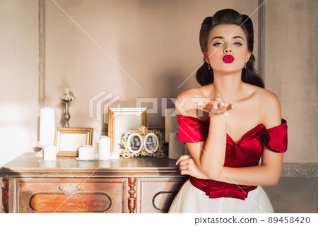 Pretty coquettish pin-up girl in retro interior. Hand kiss 89458420