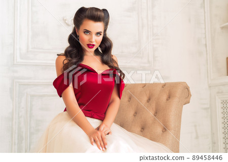 Pretty coquettish pin-up girl in retro interior 89458446