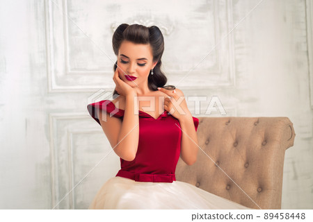 Pretty coquettish pin-up girl in retro interior 89458448