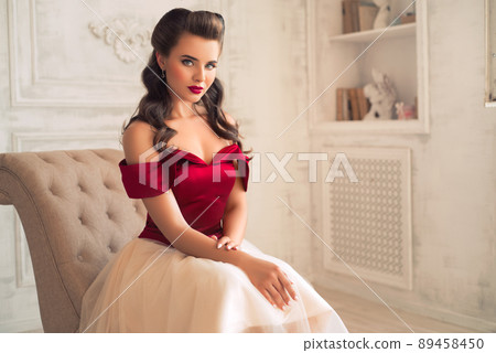 Pretty coquettish pin-up girl in retro interior 89458450