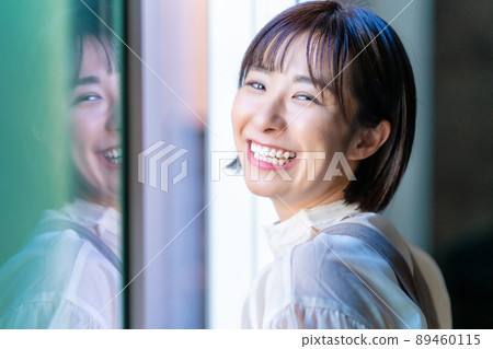 A woman who opens the window and bathes in the sun 89460115