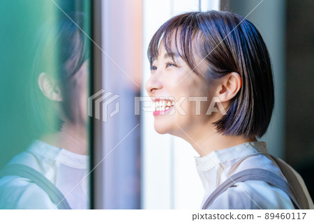 A woman who opens the window and bathes in the sun 89460117