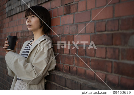 A pensive woman with a drink in her hand A pensive woman with a drink in her hand 89463659