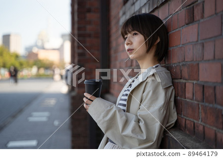 A pensive woman with a drink in her hand A pensive woman with a drink in her hand 89464179