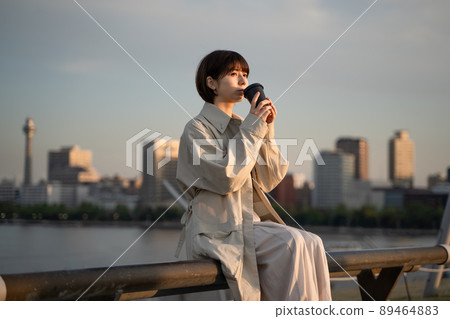 A woman relaxing on a bench 89464883