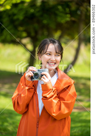 一位年輕女子在陽光明媚的日子裡用複古膠卷相機在戶外拍照 89466302