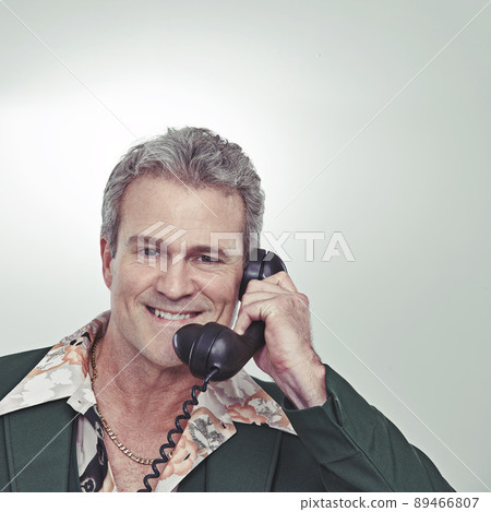 Give me a call, ladies. Cropped studio portrait of a confident mature man talking on an old-fashioned telephone. 89466807