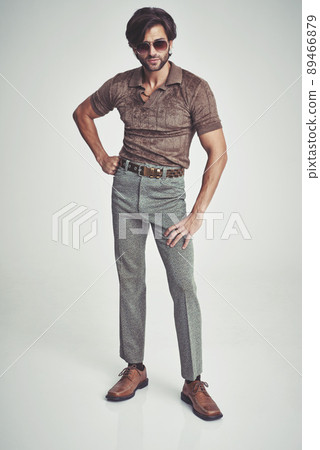 I'm kind of a big deal.... A handsome man in retro 70s clothing striking a pose in the studio. 89466879