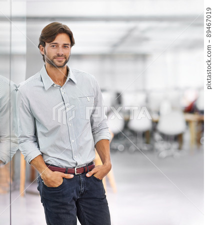 He's a confident young businessman. Portrait of a handsome young businessman standing in his office. He's a confident young businessman. Portrait of a handsome young businessman standing in his office. 89467019