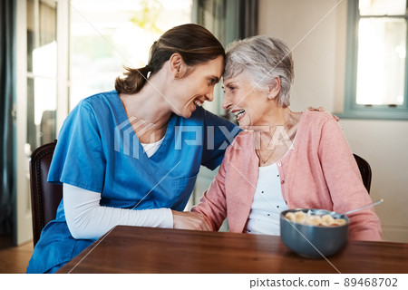 Her patient's happiness comes first. Shot of a young nurse sitting with a senior woman at breakfast time in a nursing home. 89468702